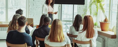 female-african-american-speaker-giving-presentation-in-hall-at-university-workshop